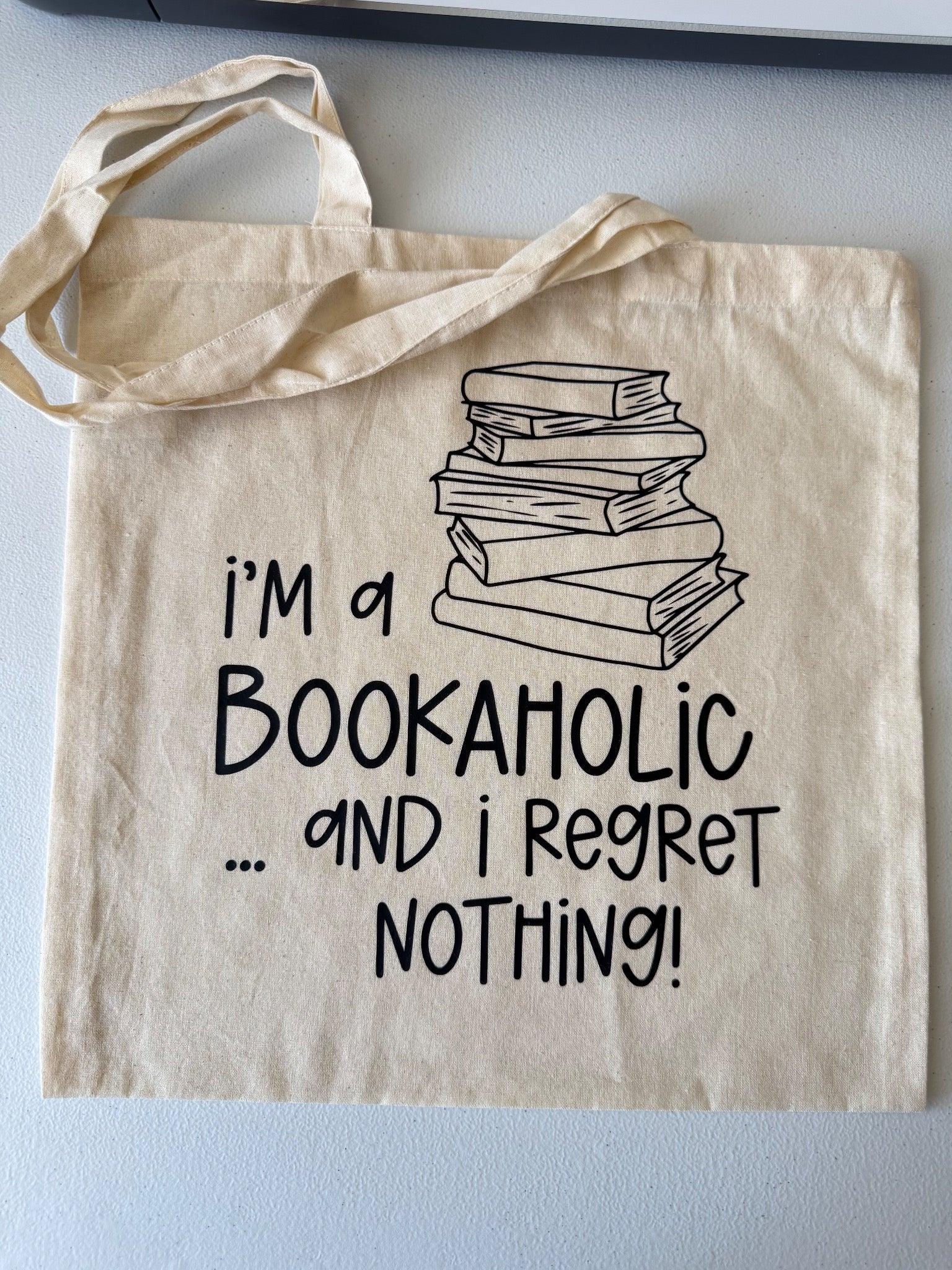 Natural canvas tote bag with an I am a bookaholic and I regret nothing design