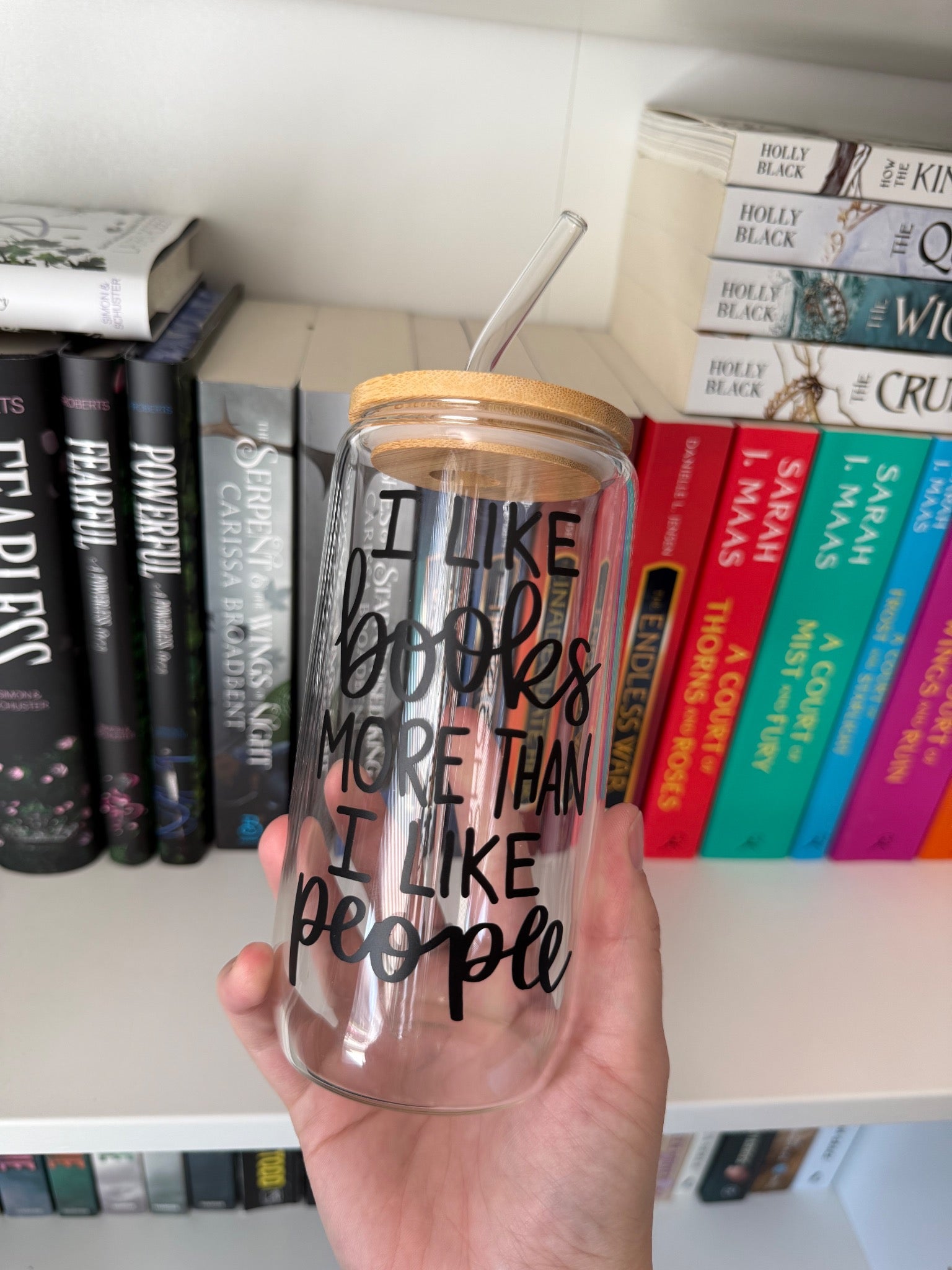 Clear glass tumbler with bamboo lid and a books-over-people quote