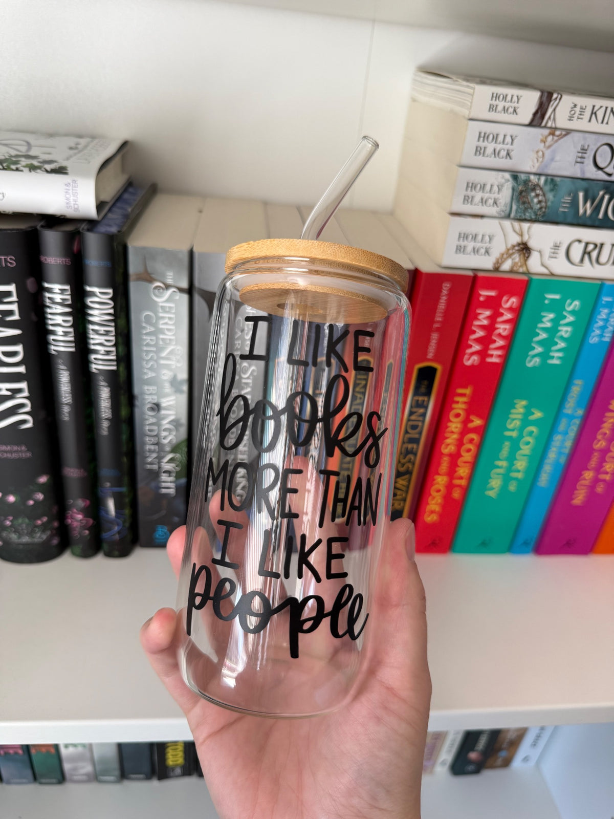 Clear glass tumbler with bamboo lid and a books-over-people quote