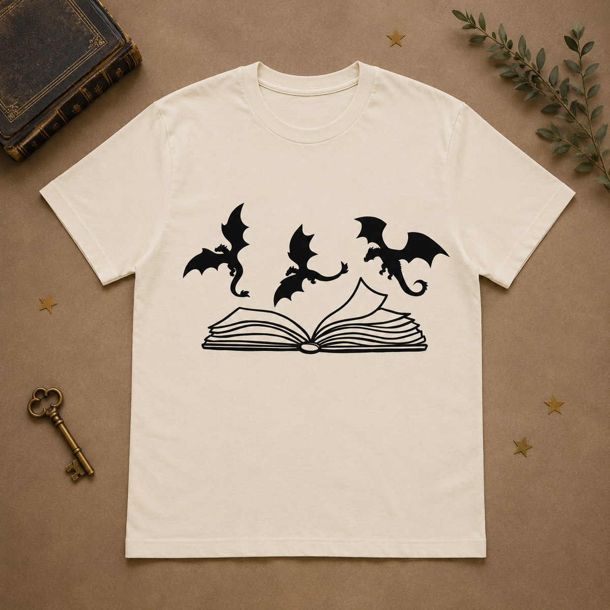 Cream T-shirt with three dragons flying over an open book
