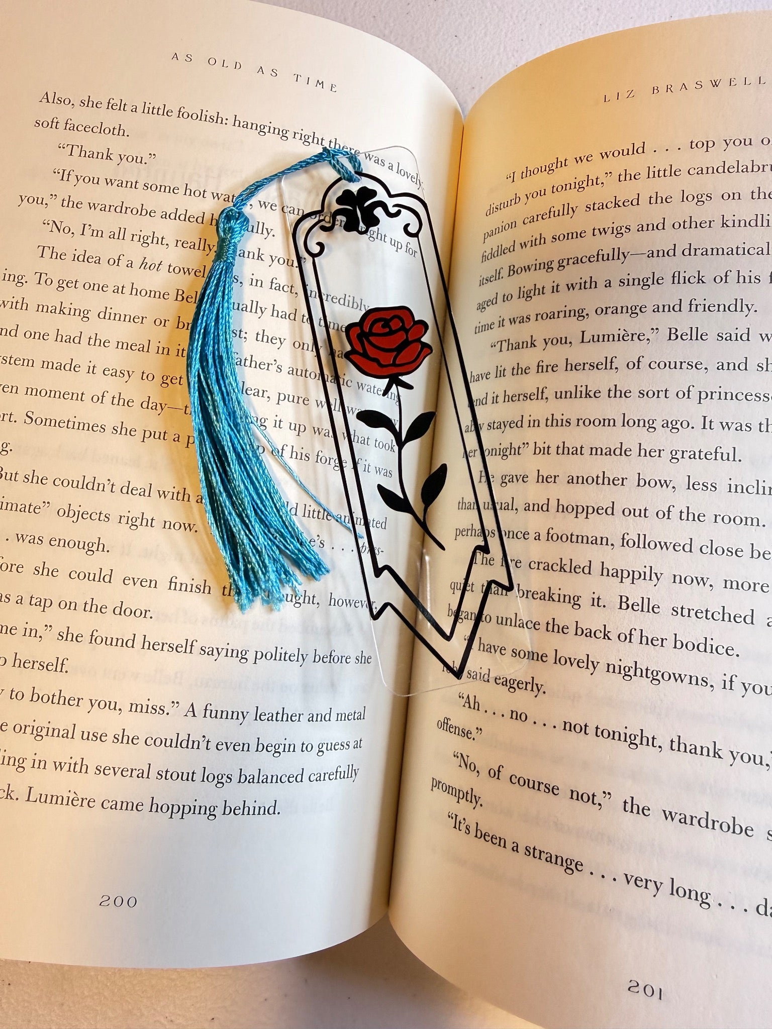 Clear bookmark with a red rose design and blue tassel
