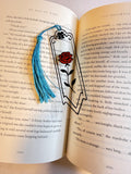 Clear bookmark with a red rose design and blue tassel