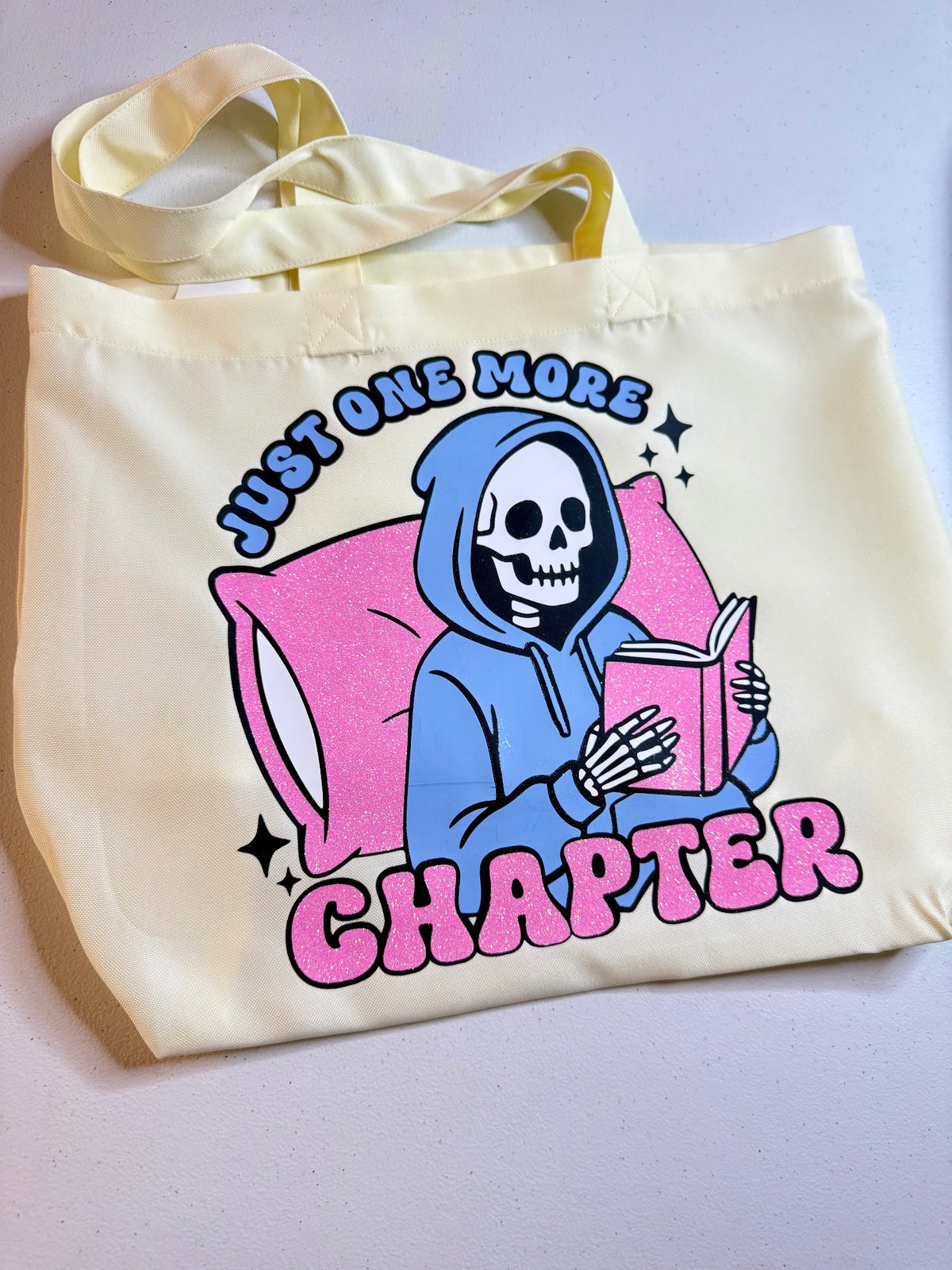 Cream tote bag with Just One More Chapter reader artwork