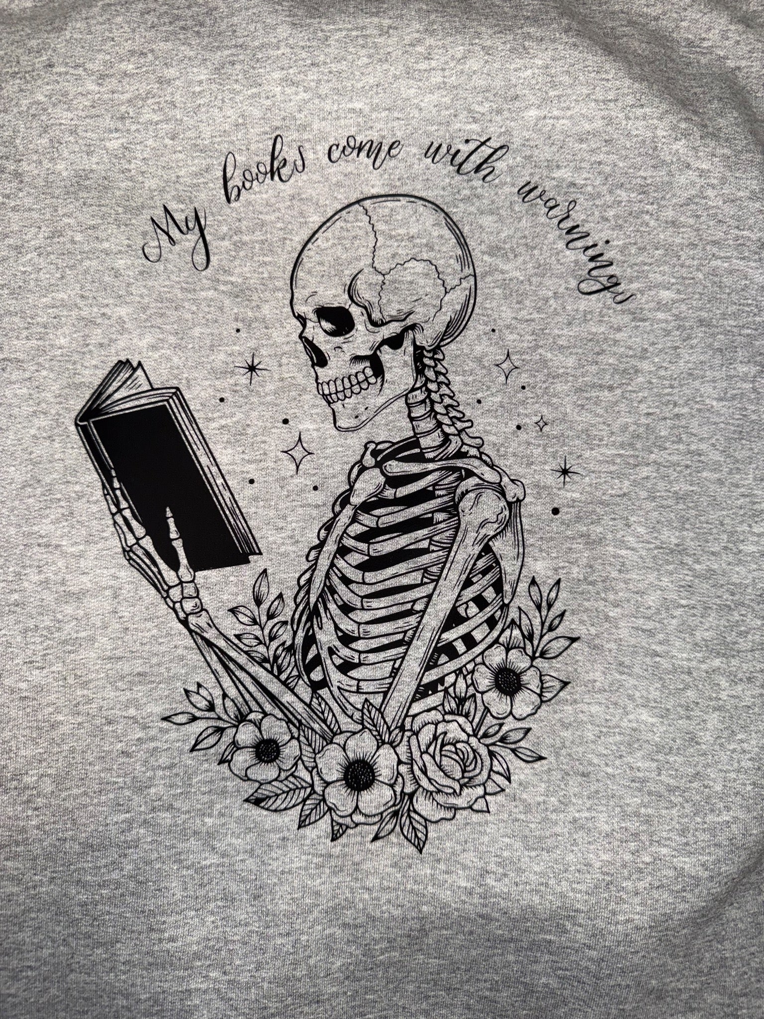 Gray hoodie with a skeleton reading and My books come with warning design